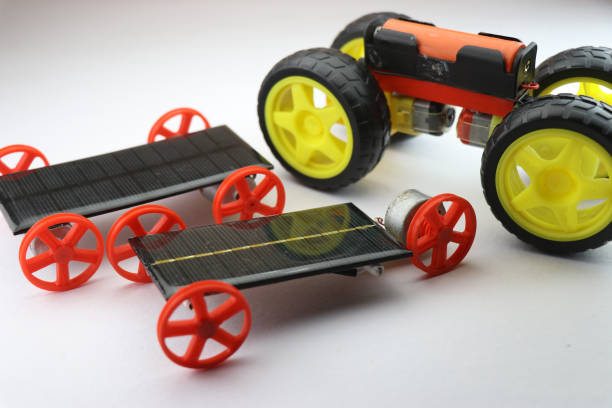 istock Small Solar powered vehicles with different sets of wheels along with electric car having big size wheels, Green energy cars mini models 1354019689