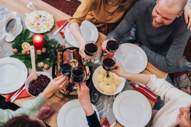 istock young people toasting with wine glasses at christmas table 1354024358