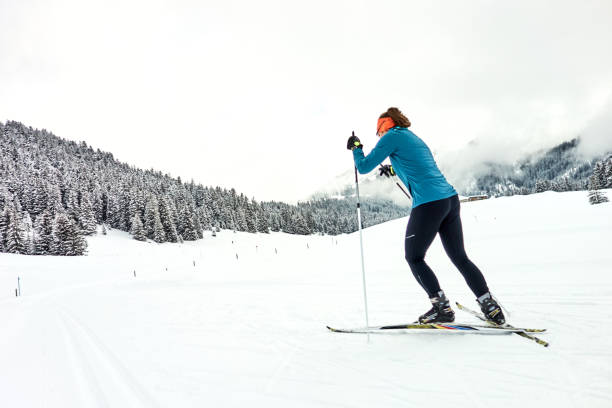 la esquiadora de skate femenina sigue la pista hacia el bosque - nordic event fotografías e imágenes de stock