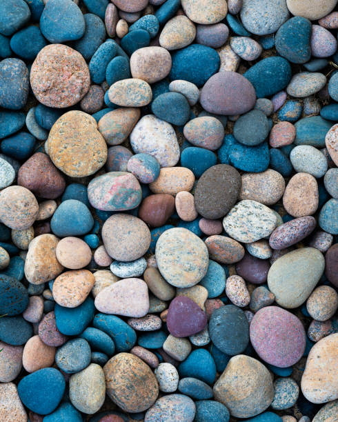 разноцветные камни на берегу озера верхнее - oval shape фотографии стоковые фото и изображения