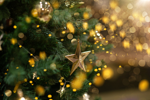 Focus on the Christmas tree star lights and bokeh near the Christmas fireplace.