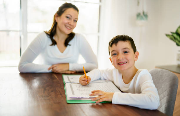 istock Mother and child doing homework at home 1354027726