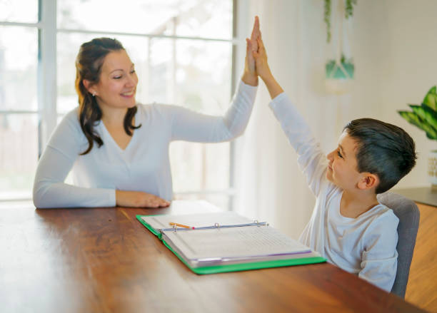 istock Mother and child doing homework at home 1354027752