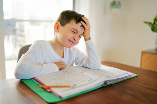 istock Thinking child bored and frustrated and fed up doing his homework 1354027755