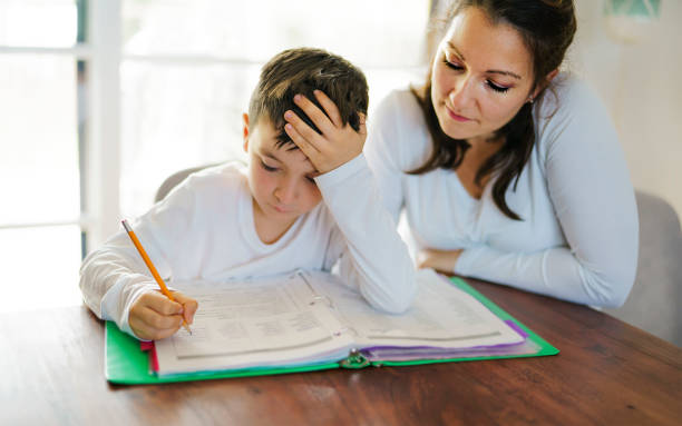 istock mother teaching bored son and helping with homework at home 1354027882