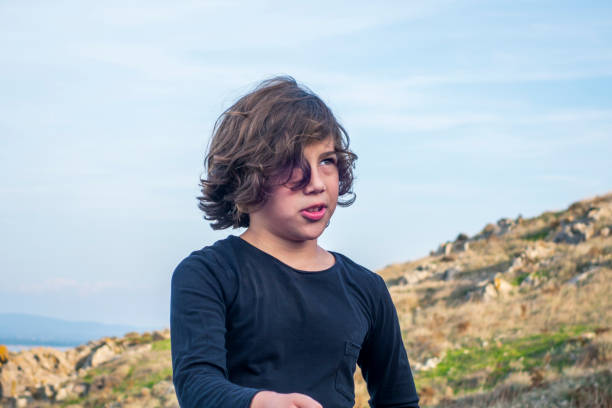 Cute boy walking by the sea in nature