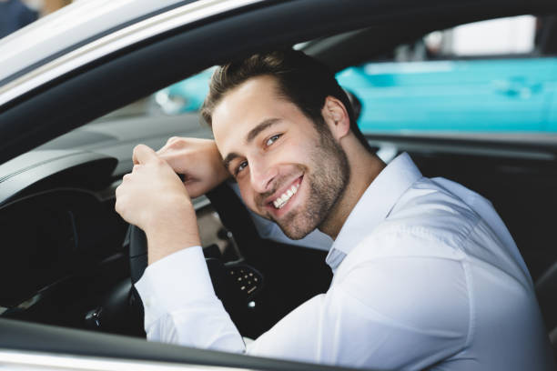istock Smiling handsome caucasian businessman in formal attire feeling comfortable satisfied while choosing buying new expensive car at dealer shop store 1354034842