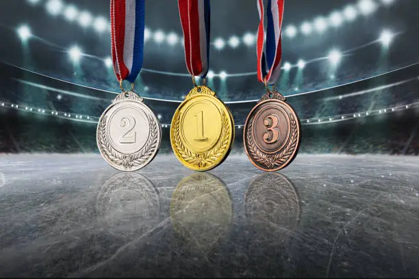 real Gold, silver and bronze medals in the large, illuminated winter ice stadium