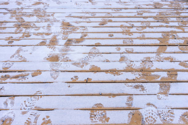 istock Wooden Floor With Footprints In The Snow 1354036541