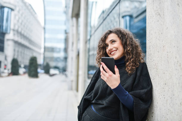 istock Smiling Female Using Phone While Enjoying View Of Beautiful City 1354036564