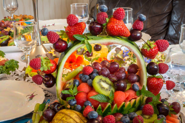istock Beautifully decorated home made  fruit basket    on table with different food snacks  party 1354039387