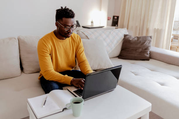 istock Handsome young businessman working on laptop computer at home. 1354039880