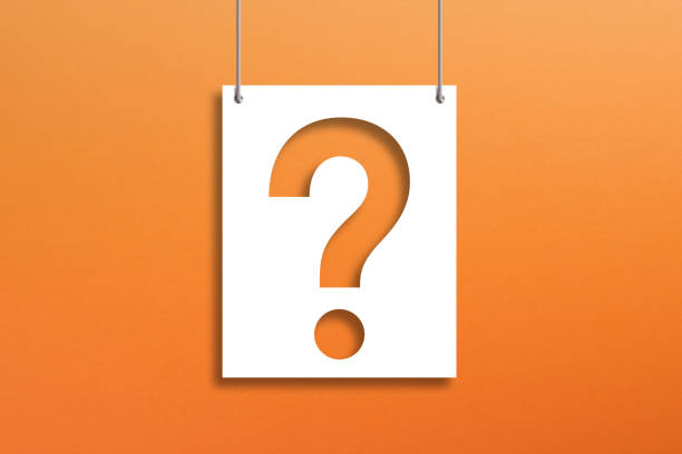 istock Question mark on paper hanging with rope on orange background 1354041368