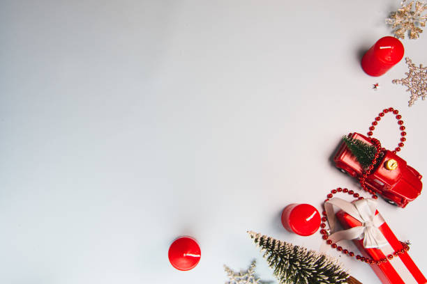 istock Christmas composition. Christmas background, gift box, red pickup trailer, christmas tree and red candles on white. 1354041431