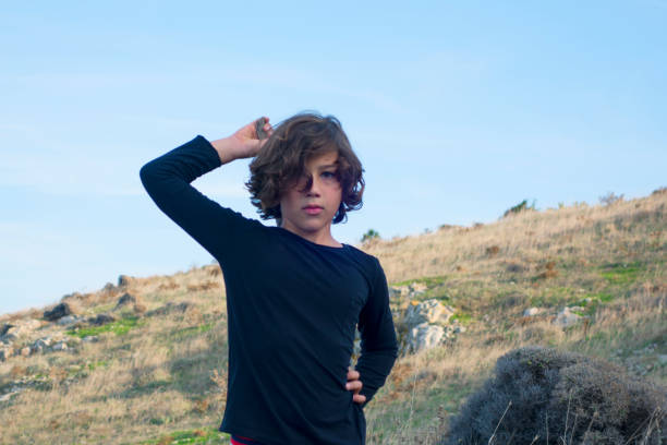 istock Cute boy walking by the sea in nature 1354042521