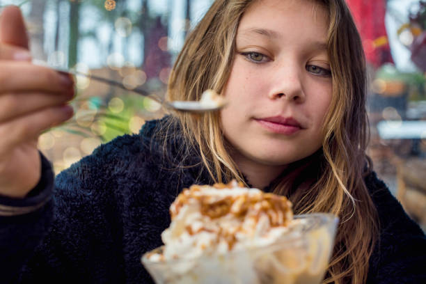 cute young girl eating big cup of ice cream