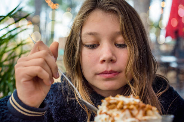 cute young girl eating big cup of ice cream