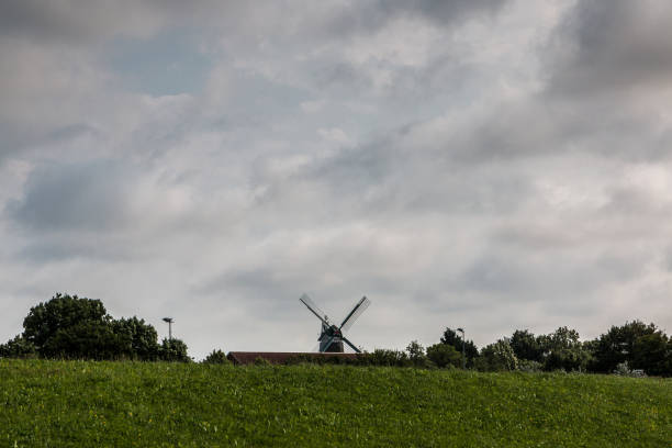 Big windmill in the green countryside and a cloudy sky