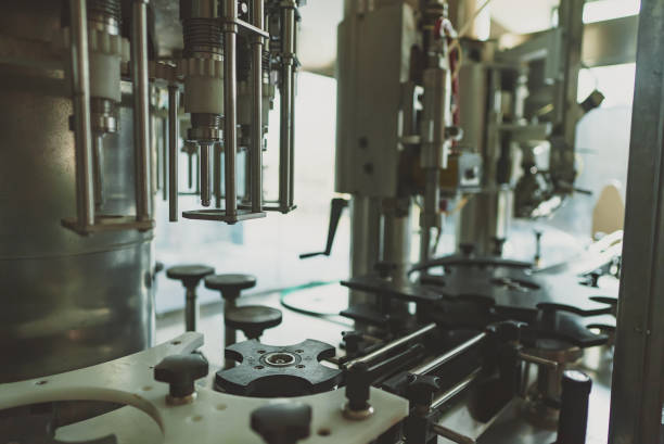 istock Automatic monoblock wine filling machine at wine factory. 1354045537