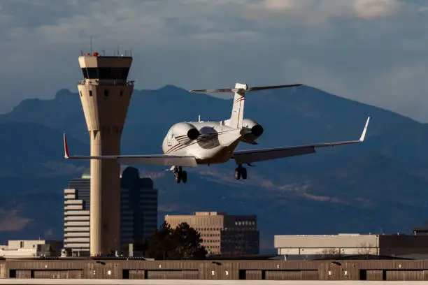 Learjet landing with control tower background