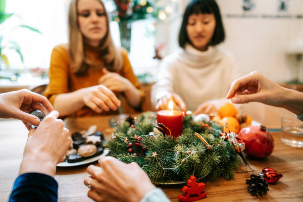istock friends sitting at christmas table with advent wreath 1354050626