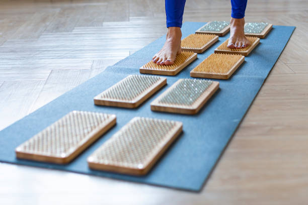 istock Woman walking on a board with sharp nails over white background. Sadhu's board - practice yoga 1354052206