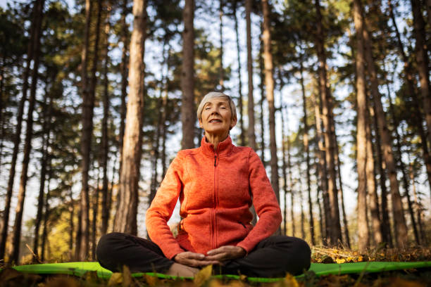Senior woman practicing yoga workout routine stock photo