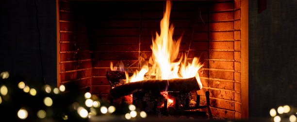 istock Christmas tree and burning fireplace, bonfire fire flames and festive decoration lights. 1354053387