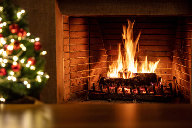 istock Christmas tree and burning fireplace, bonfire fire flames and festive decoration lights. 1354053443