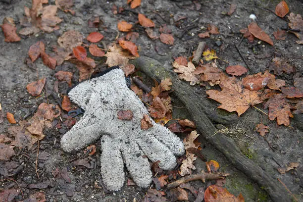 Photo of lost single glove in the dirt on the ground