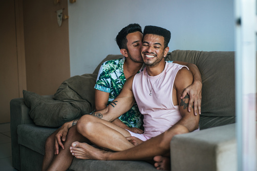 Gay couple in love. Home sofa. Valentine's Day.
