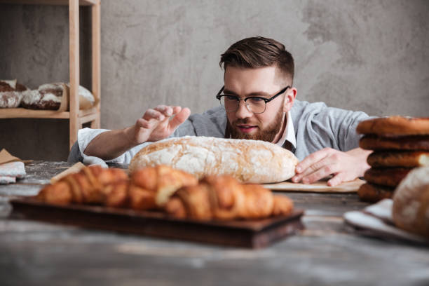 istock Concentrated man baker standing at bakery near bread. 1354060834