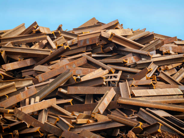 Stack of rusty old railway track sections A stack of rusty old sections of railway track in a scrap metal yard. kings lynn stock pictures, royalty-free photos & images