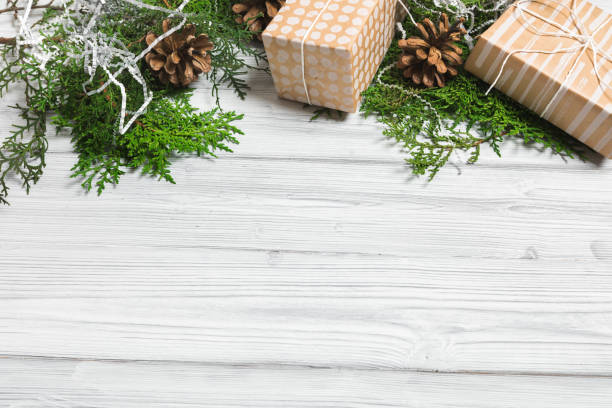 istock Christmas branches, gift boxes and pine cones on white wooden table. Christmas background. Flat lay. top view with copy space 1354062195