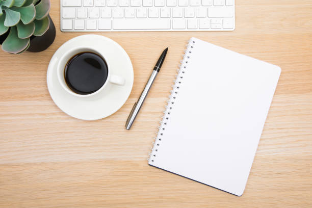 istock open notepad, cup of coffee, pen ,moose, keyboard on wooden background spiral notebook on table Business, planning, education, morning life working from home concept Top view Flat lay Mock up 1354062613