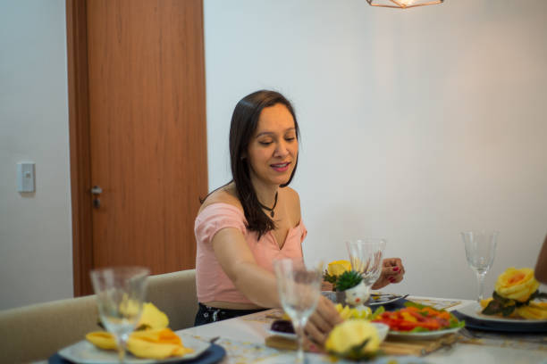 istock woman serving food at table set. 1354064125
