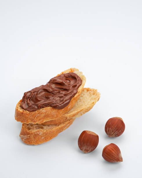 istock Slices of toast with chocolate hazelnut spread, knife on white background, space for text. 1354068678