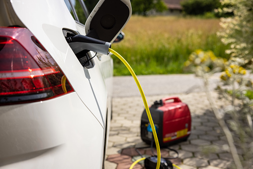 Charging an electric car battery at home parking lot