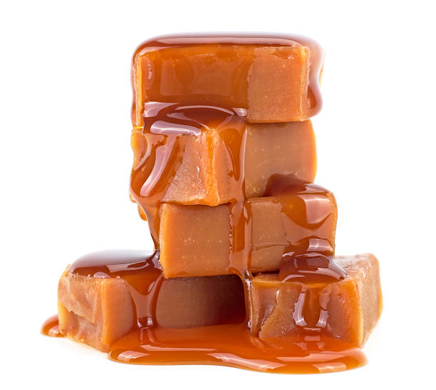 süße karamellbonbons mit geschmolzenem karamell isoliert auf weißem hintergrund - karamelisiert stock-fotos und bilder