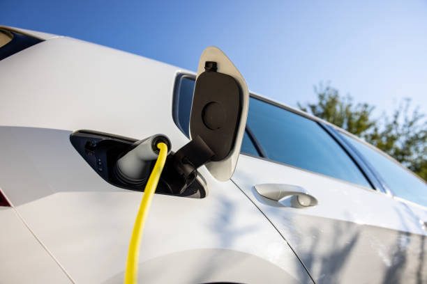 istock Charging an electric car under blue sky at home 1354072168