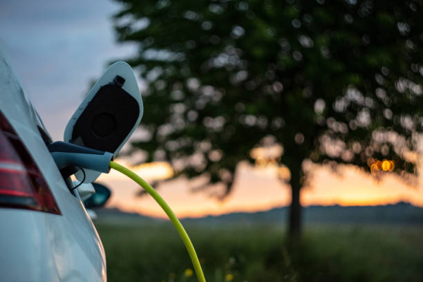 Charging an electric car on rural field stock photo