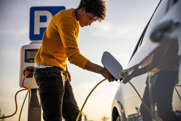istock African american man inserting plug into the electric car charging socket 1354074575