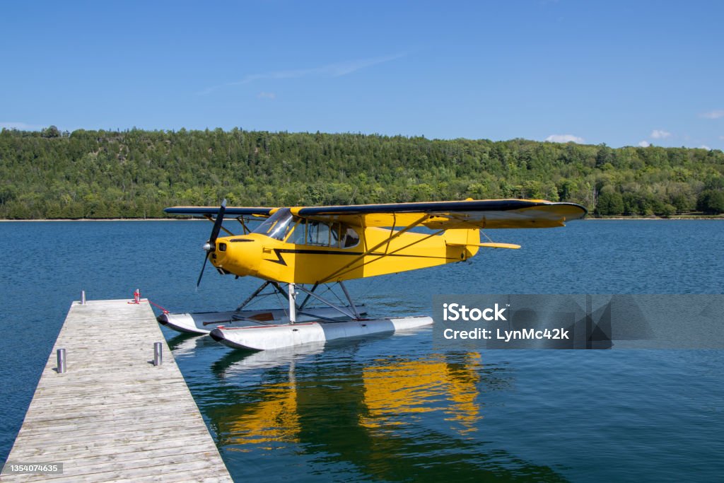 Yellow seaplane at a dock Yellow seaplane tied to a dock at Gore Bay on Manitoulin Island Private Airplane Stock Photo