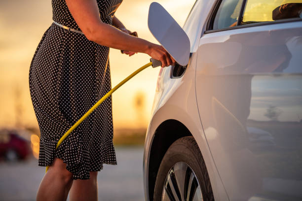 istock Woman's hand inserting charger into electric car 1354075234
