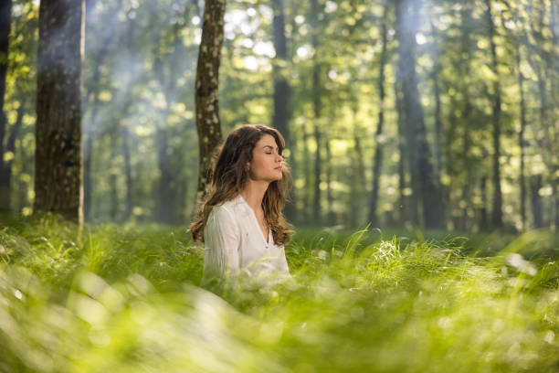 Young woman sitting in forest stock photo