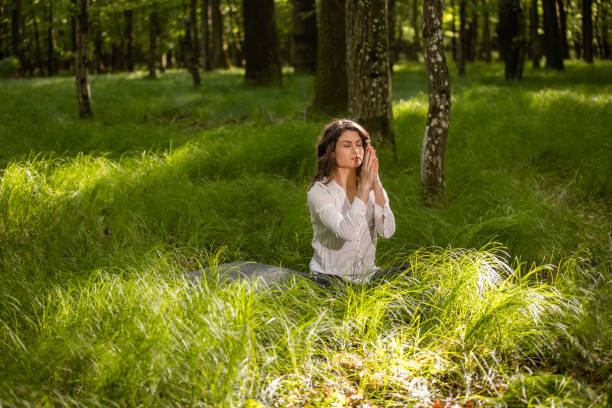 istock Young woman meditating with joined hands 1354076491