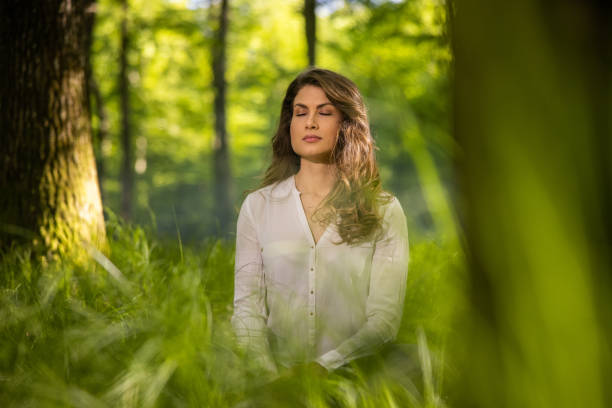 istock Woman meditating in forest 1354077268