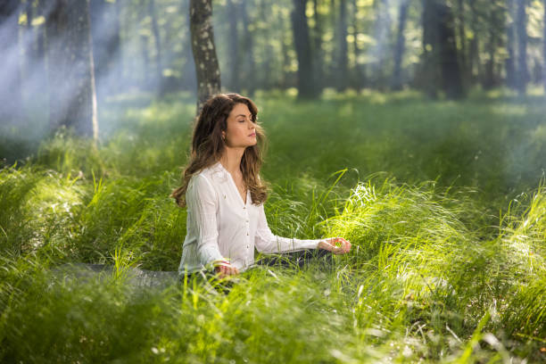 istock Beautiful young woman practicing yoga at forest 1354077336