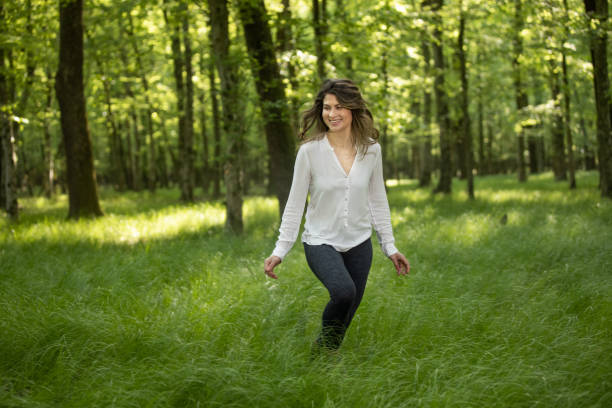 istock Happy woman walking in forest 1354077502