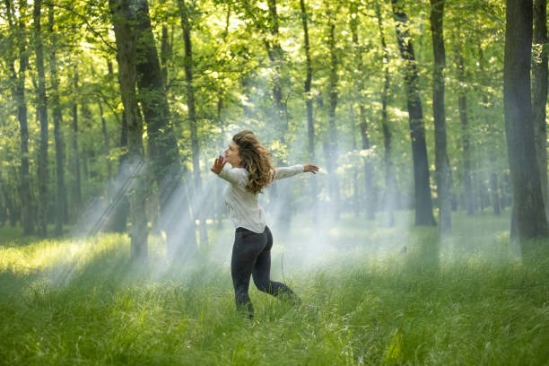 istock Young woman spinning in forest 1354077673